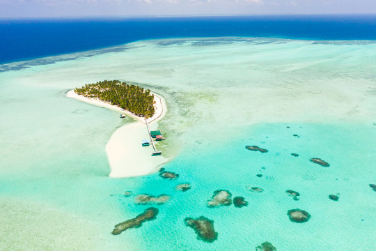 Seascape with a paradise island. Onok Island Balabac, Philippines. A small island with a white sandy beach and bungalows. Philippine Islands.