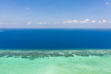 Atoll and blue sea, view from above. Seascape by day. Turquoise and blue sea water.