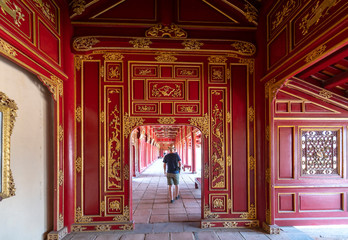 Tourists visit walk along wooden hallway corridors of the Thai Hoa Palace in the Imperial City in Hue, Vietnam. © huythoai