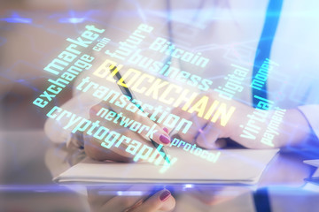 Cryptocurrency hologram over woman's hands writing background. Concept of blockchain. Double...