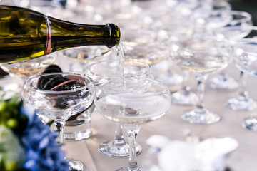 champagne from  bottle  pours into a beautiful clean glass
