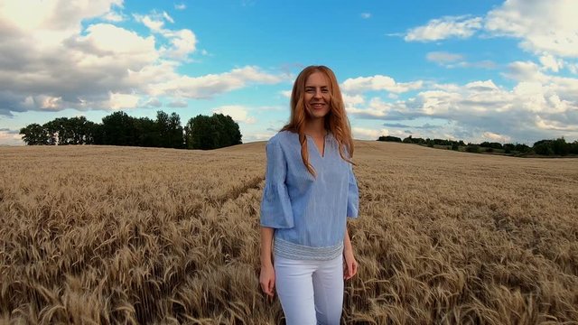 Red-haired girl runs through the rye field