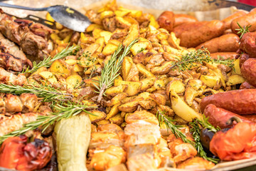 Fried potatoes with fried sausages in a pan. Dish fried potatoes with sausages, onions, garlic, cumin, pepper and seasonings.