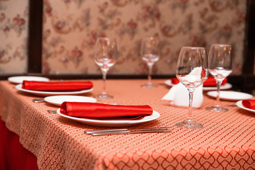Table setting in the restaurant. Red tablecloths and napkins