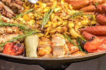 Fried potatoes with fried sausages in a pan. Dish fried potatoes with sausages, onions, garlic, cumin, pepper and seasonings.