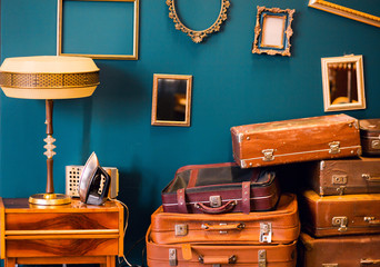 Many things - suitcases, a lamp, an iron, photo frames - in one room