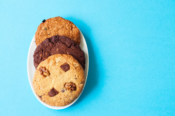 Three types of cookies in a plate on a blue background.