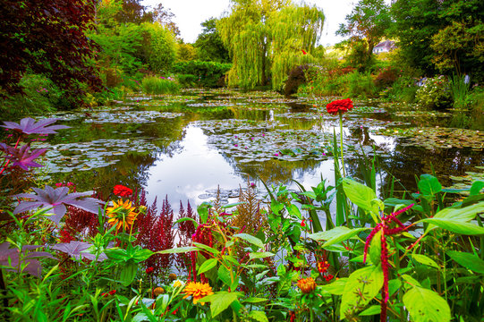 Monet’s garden and pond at Giverny, France. Beautiful garden and pond with clustered of colorful flowers, variety of trees and shrubs in summer at Giverny.