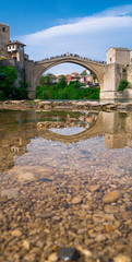 Fototapeta na wymiar Stari Most bridge and its reflection in river Neretva - Old town of Mostar, Bosnia and Herzegovina, April 2019