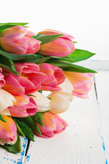 Bouquet of fresh pink tulips on white wooden background. Close up.