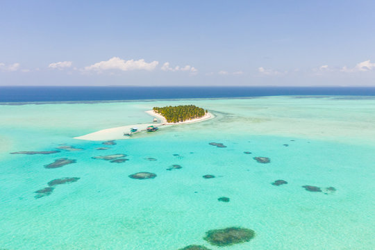 Seascape with a paradise island. Onok Island Balabac, Philippines. A small island with a white sandy beach and bungalows. Philippine Islands.