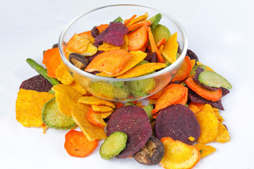 Healthy vegetable chips yellow sweet potato purple sweet potato carrot green radish green beans and shiitake mushrooms in glass bowl