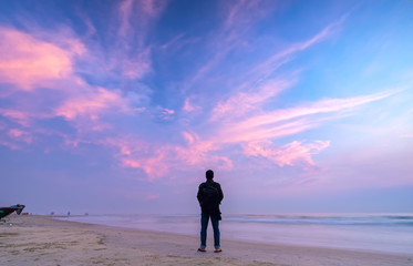 Silhouette man standing in front of the sea with sunrise sky in the morning as a way to relax during travel new land in Hue, Vietnam