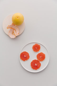 A plate of sliced parts of red grapefruit.