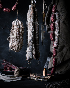 Cured meats hanging in a moody setting