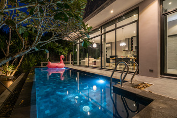 night exterior home with swimming pool in the house
