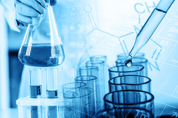 hand of scientist holding flask with lab glassware and test tubes in chemical laboratory background, science laboratory research and development concept