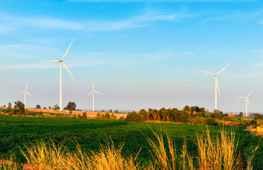 Wind turbines electric power generator on blue sky at farmer field
