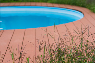 Fototapeta na wymiar fragment of home pool for relaxing spa on the background of green grass
