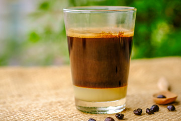 a glass of black coffee with condensed milk in retro style coffee shop