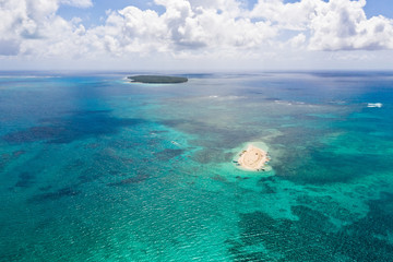 Naked Island, Siargao. The island of white sand on the atoll. Tourists relax on the white island. Seascape with sandy island.