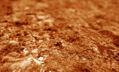 Old stone surface with blur effect in orange tone.