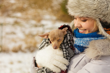 Woman hug warming her little dog in winter