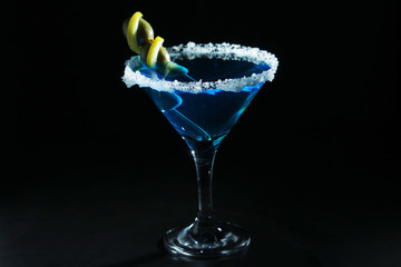 A glass with blue martini cocktail	