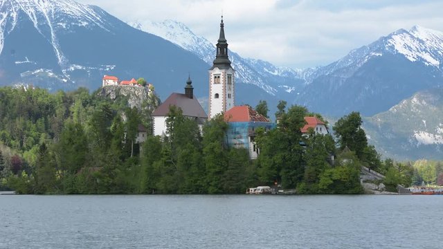View of lake Bled island with snow covered mountains in the back