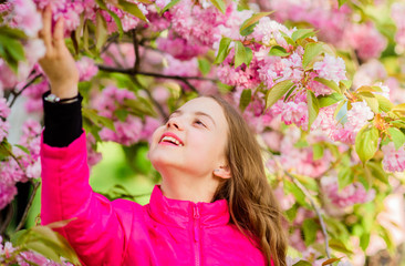 Fototapeta premium summer holiday. Childhood beauty. skincare spa. Natural cosmetics for skin. happy girl in cherry flower. Sakura tree blooming. small girl in spring flower bloom. blossom smell, allergy. Spring beauty