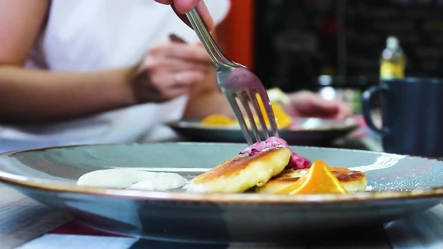 people eat cheesecakes with sauces