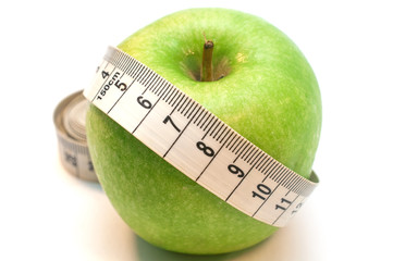 Green apple wrapped by measuring tape isolated on white background