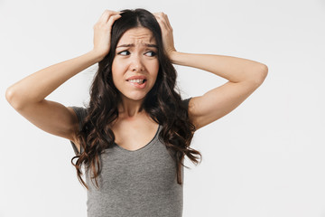 Fototapeta premium Beautiful confused displeased young woman posing isolated over white wall background.