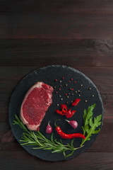 Beef steaks with rosemary on cutting board