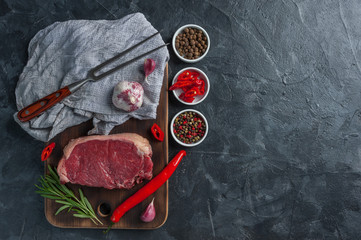 Beef steaks with rosemary on wooden board