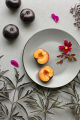 Plums on plate decorated with elderberry leaves