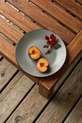 Sliced plums on a grey plate with rose bud
