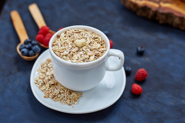 Raspberries and blueberries on blue background. Cereals.