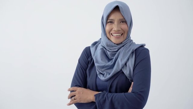 Pose of old hijab woman with crossed hands and smile look at camera at isolated background