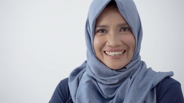 Close up of old hijab woman with crossed hands and smile look at camera at isolated background