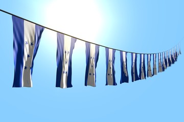 cute any feast flag 3d illustration. - many Honduras flags or banners hanging diagonal on rope on blue sky background with soft focus