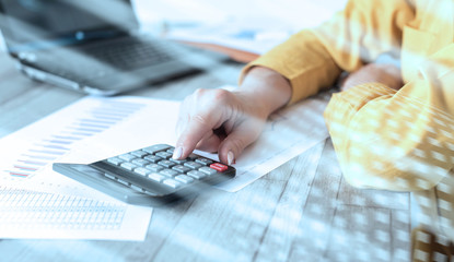 Fototapeta premium Hands of an accountant working on financial documents; light effect