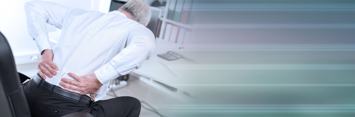 Businessman suffering from back pain; panoramic banner