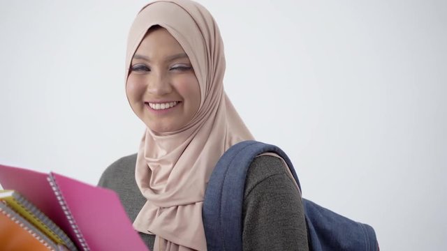 Portrait of beautiful college student look eager to learn carrying books and bag at isolated background