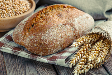 Sliced freshly baked ciabatta bread on wooden cutting board on rustic table. Italian food concept.