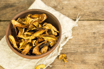 Dry mushroom chips in a bowl wooden background