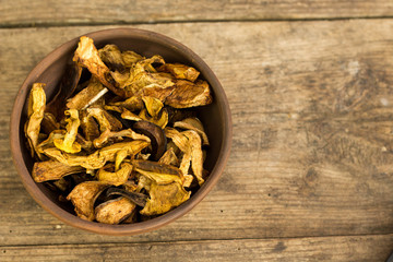 Dry mushroom chips in a bowl wooden background