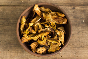 Dry mushroom chips in a bowl wooden background