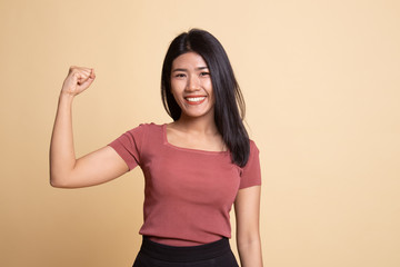 Obraz premium Beautiful young Asian woman flex bicep.
