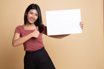 Fototapeta na wymiar Young Asian woman show thumbs up with white blank sign.